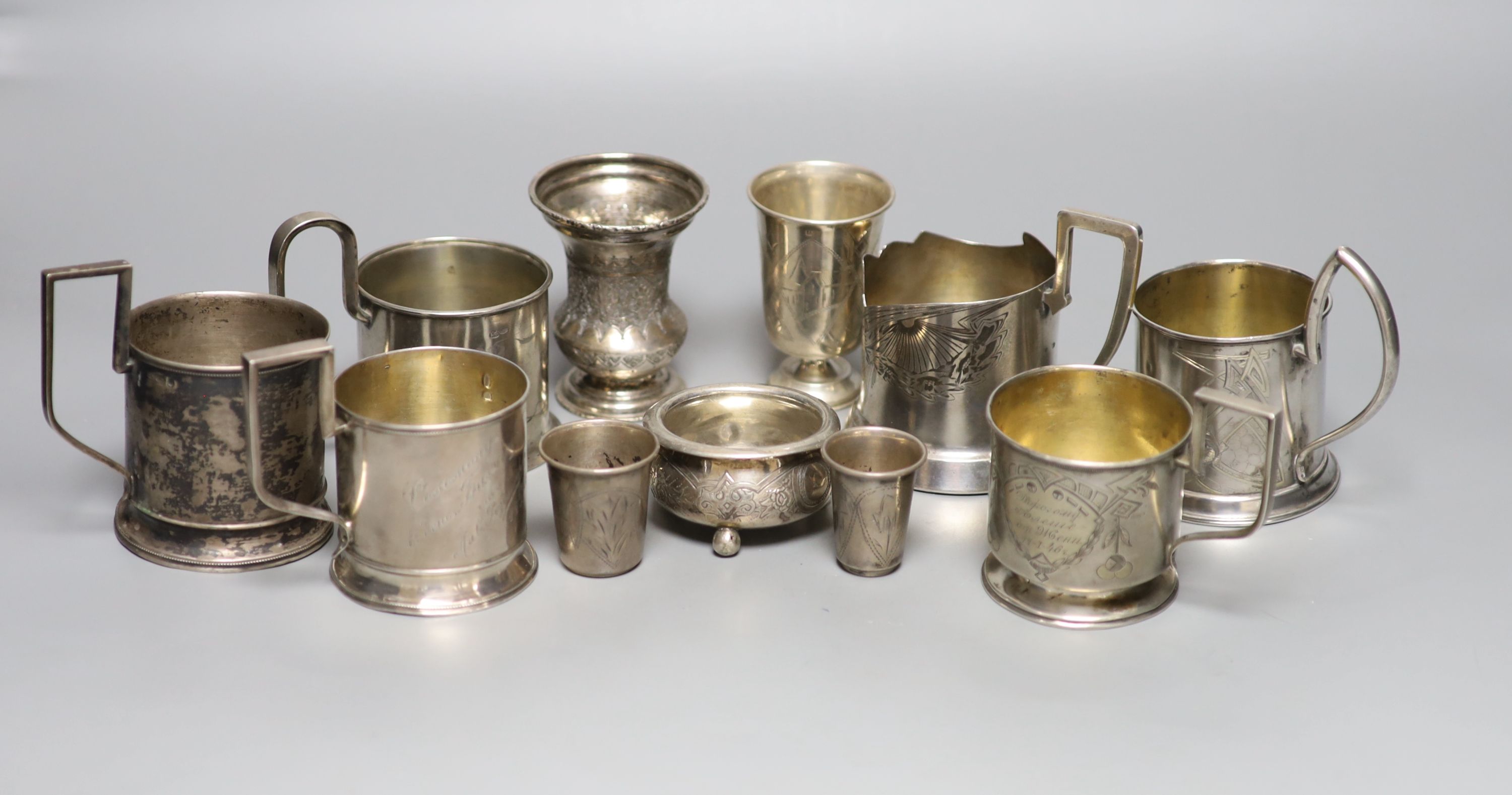 A group of six Russian early 20th century 84 zolotnik podstakanniks, two small vases, two tots and a salt
